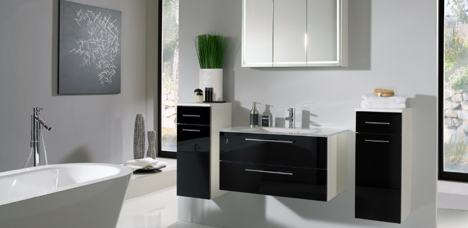 Black and white interior designed bathroom with a ceramic bathtub
