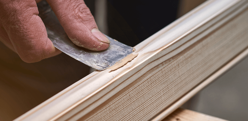 Man putties an uneven surface