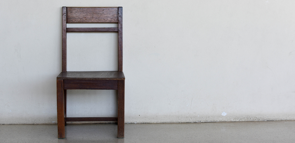 Wooden chair beside a wall
