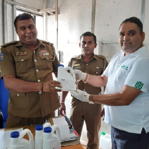 JAT employee donating hand sanitizers to police officers