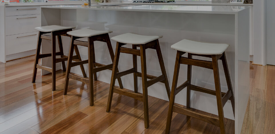 A kitchen with wooden chairs and wooden flooring